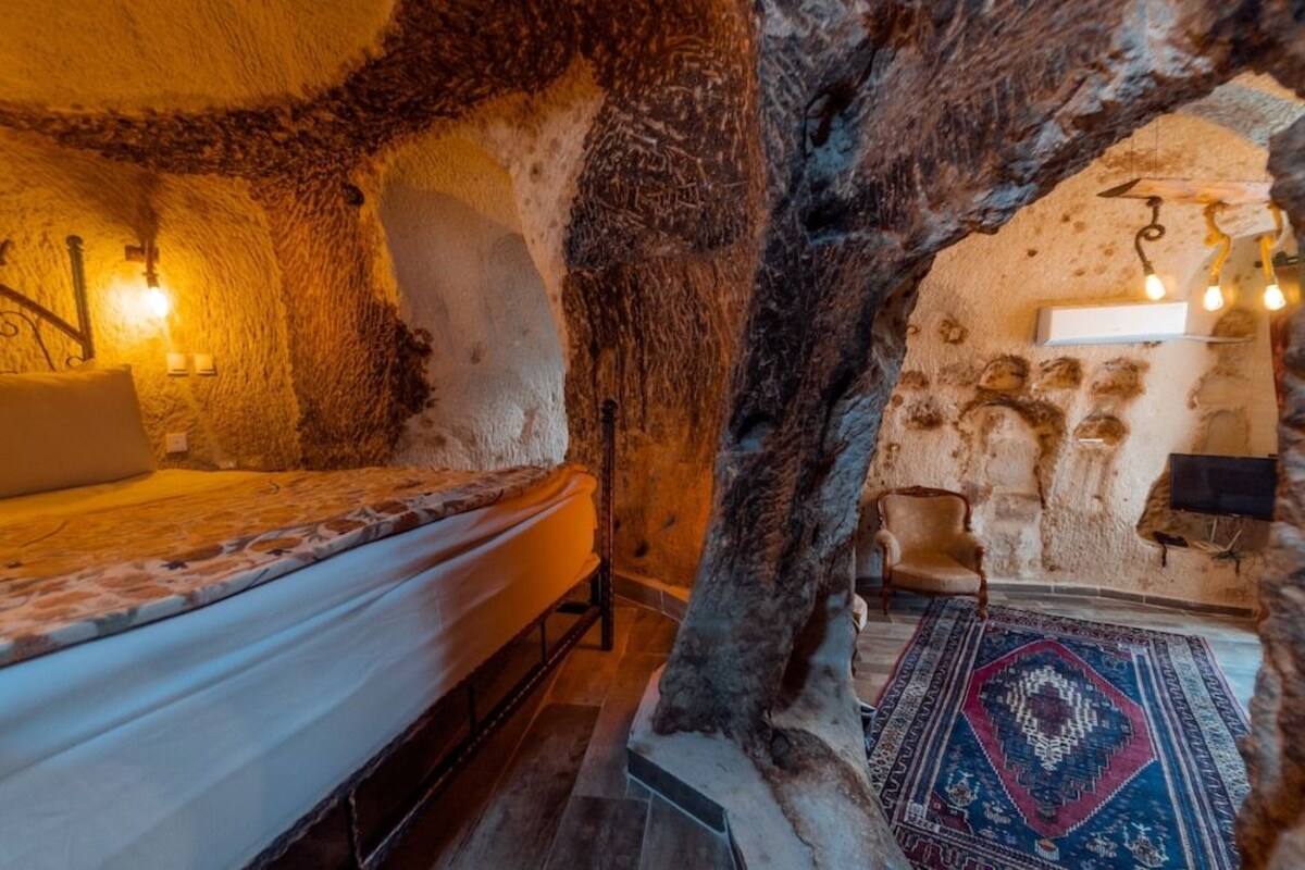A cozy room with a bed, a chair, and a rug.