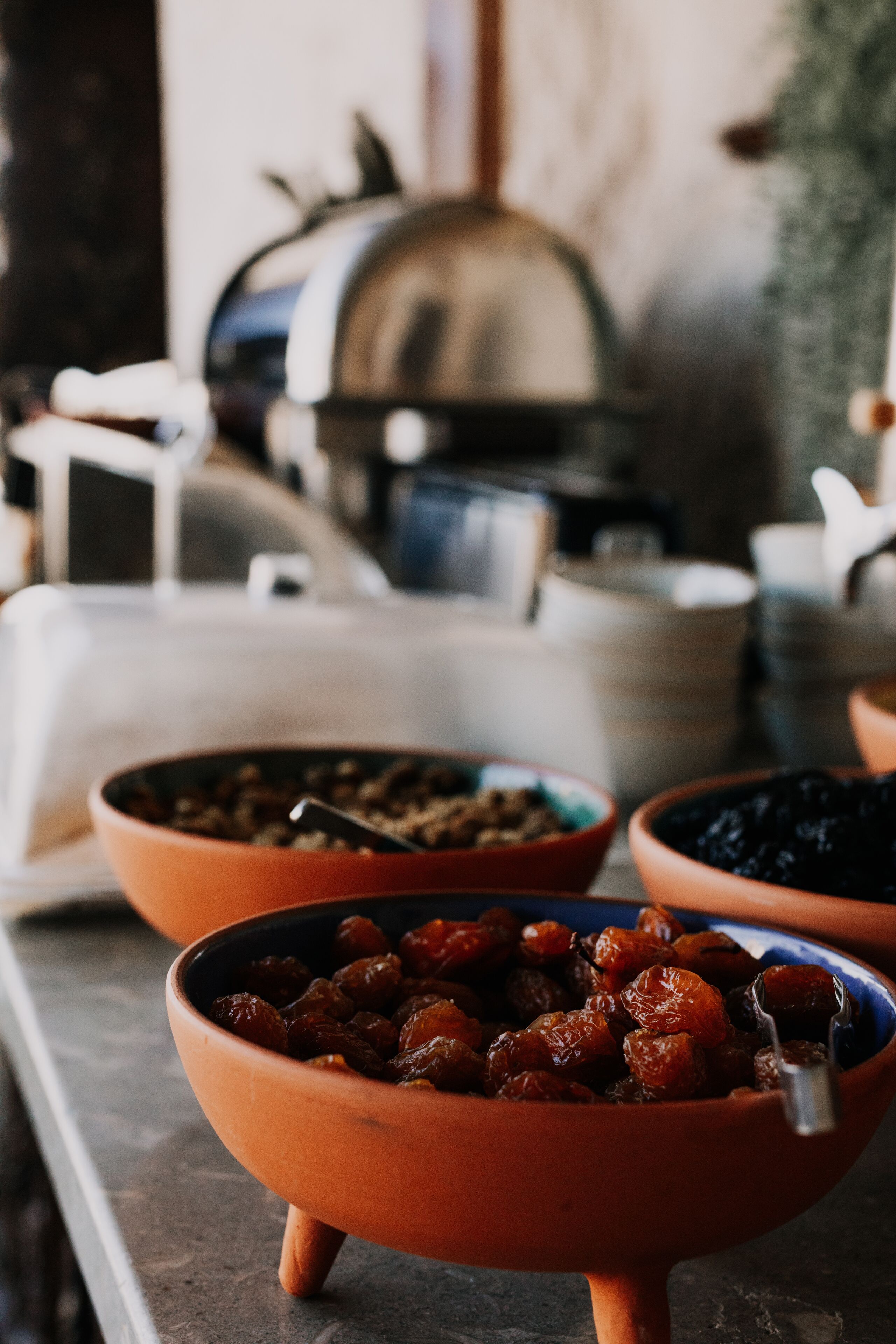 A buffet table with bowls of food, including a bowl of dates.