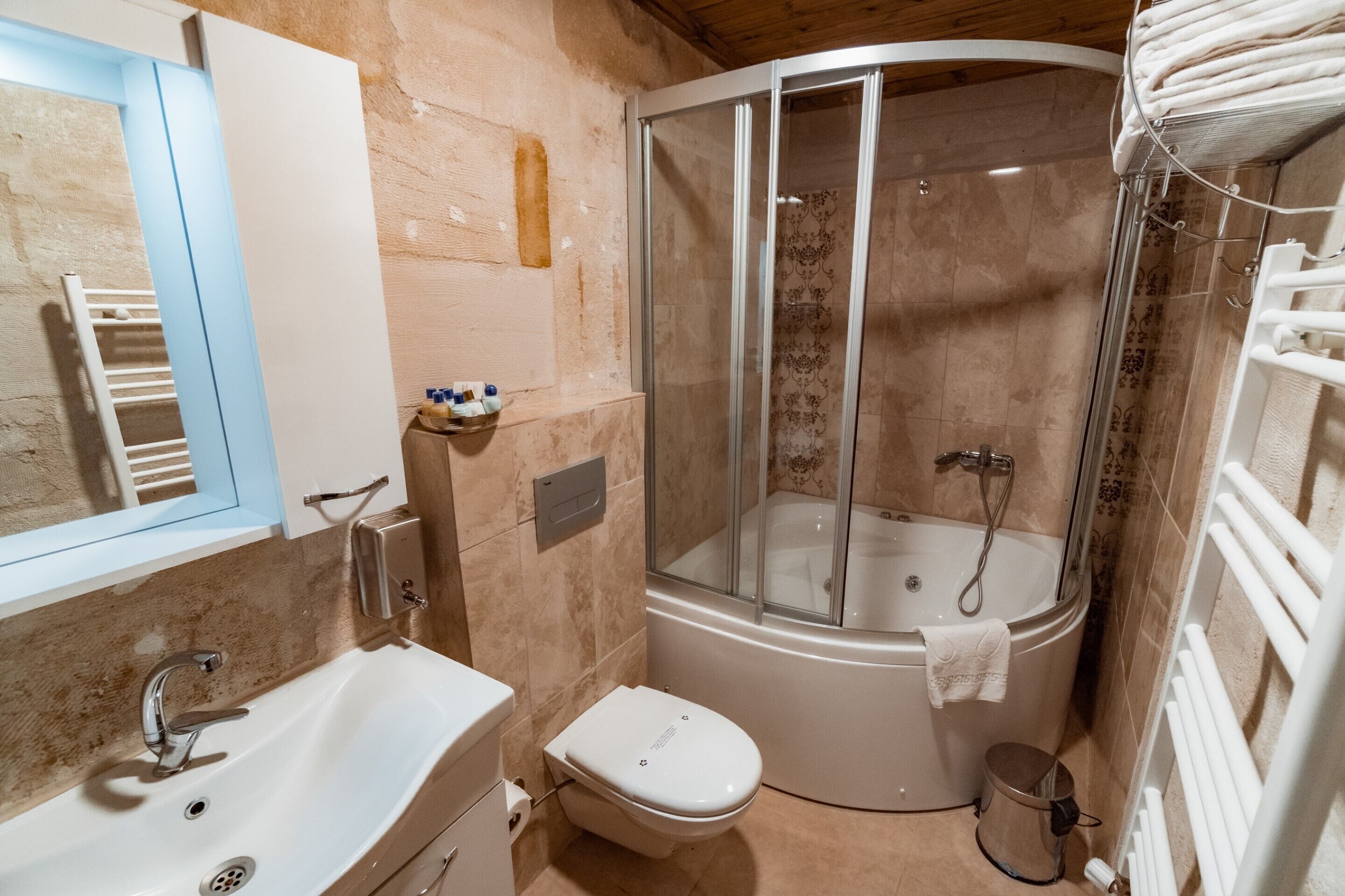 A compact bathroom with a shower enclosure, a toilet, and a sink.