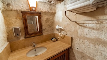 A bathroom with a sink, mirror, towel rack, and a hand dryer.