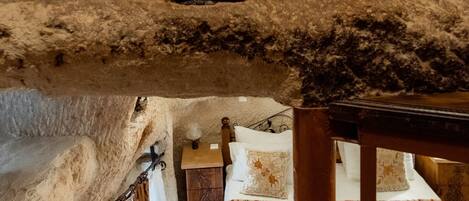 Un intérieur rustique avec un lit en mezzanine, un lit superposé et un banc en bois.