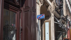 A building with a "TAXI" sign, a door with a "5 RUSKA" sign, and a window with a metal gate. - Gold Apartments (Wroclaw)