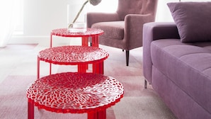 A modern living room with a purple sofa, a red and white patterned table, and a red lamp. - Gold Apartments (Wroclaw)