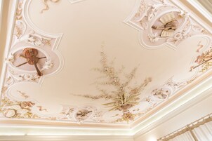 Un soffitto decorato con motivi floreali e geometrici, un violino e un leggio.