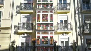 A multi-story building with balconies, decorative window frames, and a symmetrical facade. - Dato 2 (Vitoria-Gasteiz)