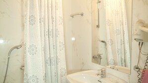A bathroom with a shower, a sink, and a mirror. - Dato 2 (Vitoria-Gasteiz)