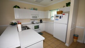 A kitchen with white cabinets, a microwave, an oven, a refrigerator, and a sink. - 612 Willow Bend (North Myrtle Beach)