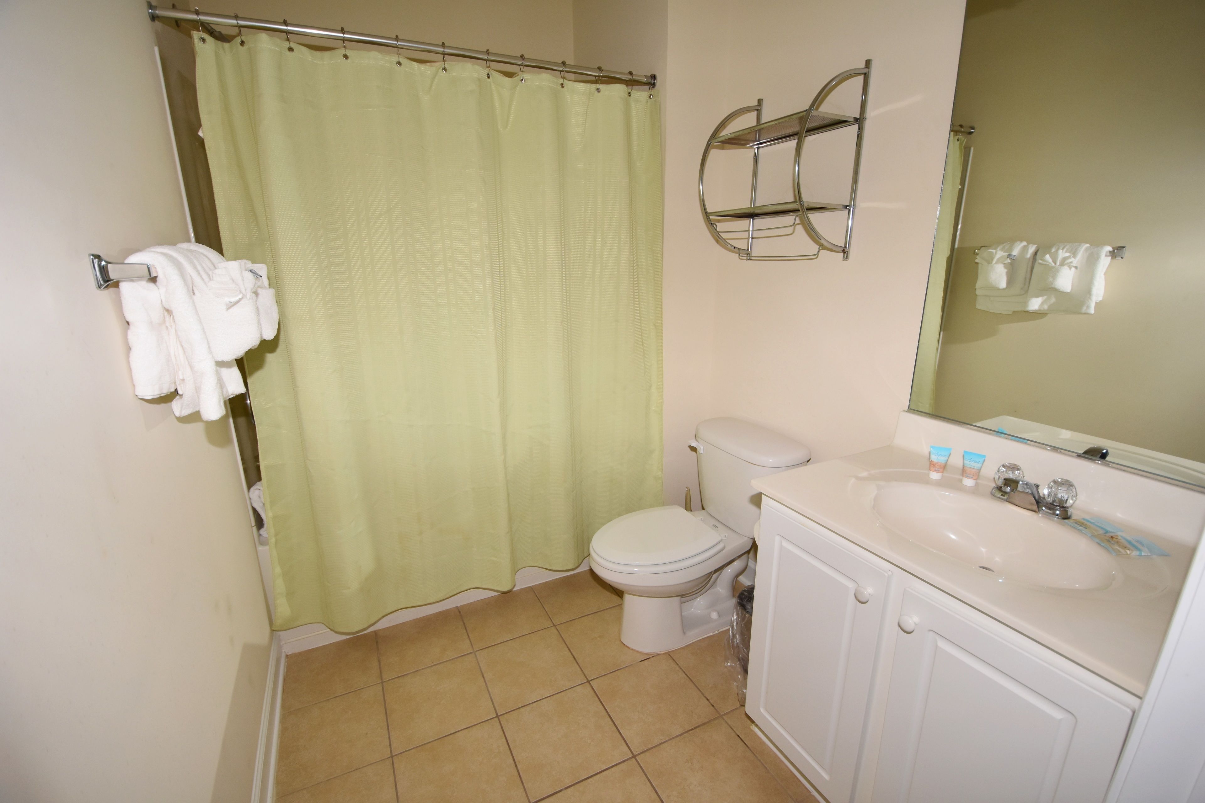 A bathroom with a toilet, sink, and shower curtain.