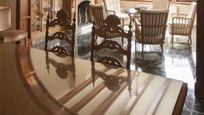 A dining area with a marble table, wooden chairs, and a view of the outdoors through a large window. - Hotel Boutique Mar d'Amunt (Port de la Selva)