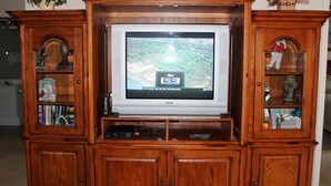 A wooden entertainment center with a flat-screen TV displaying a golf channel. - 432 Willow Bend (North Myrtle Beach)