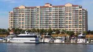 A large hotel with multiple balconies and a marina with boats.