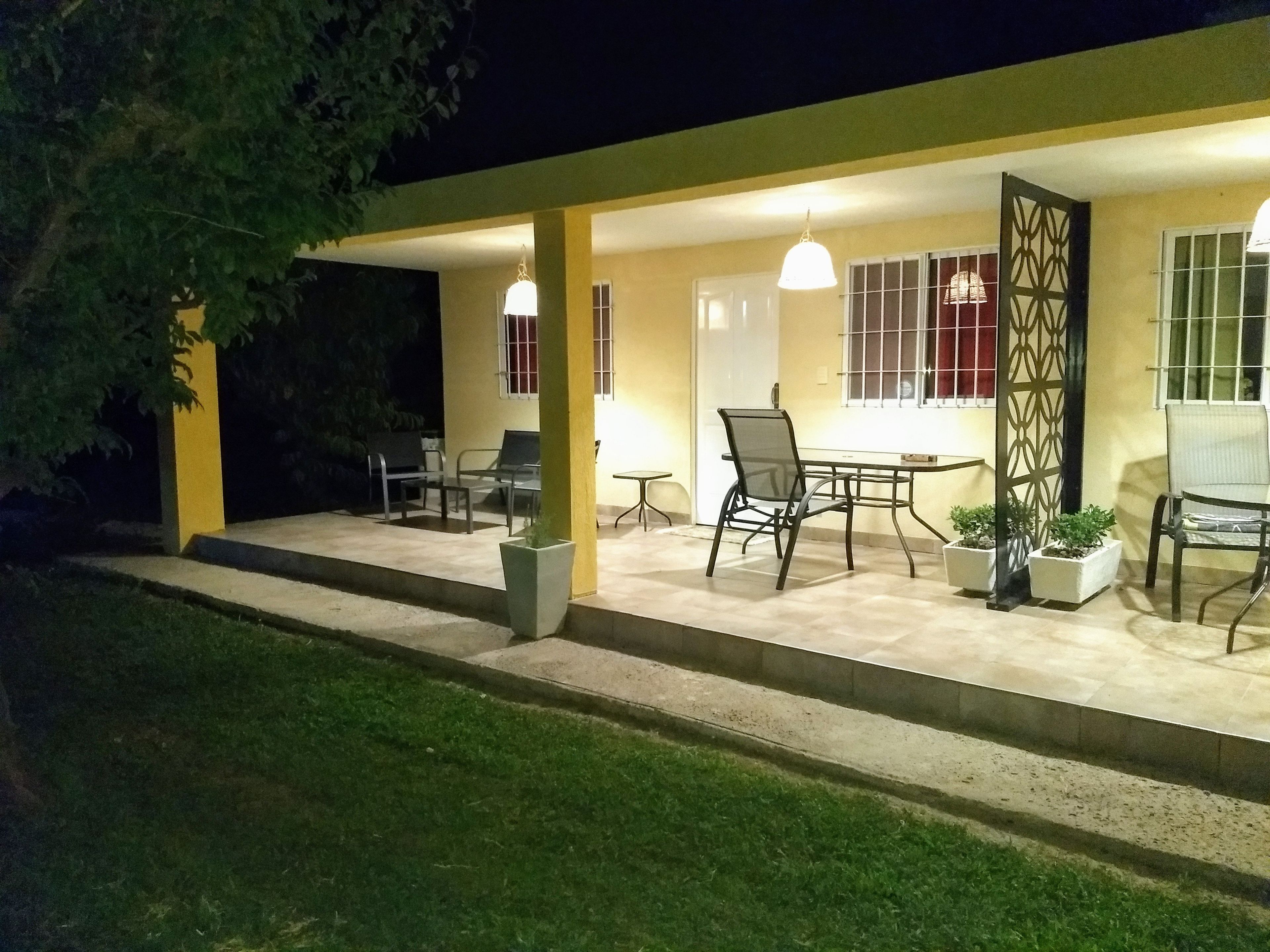 An outdoor patio area with a table and chairs, a decorative gate, and potted plants.