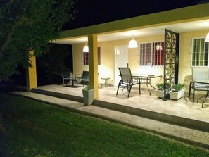 An outdoor patio area with a table and chairs, a decorative gate, and potted plants. - Finca Fisterra (Fray Luis Beltrán)