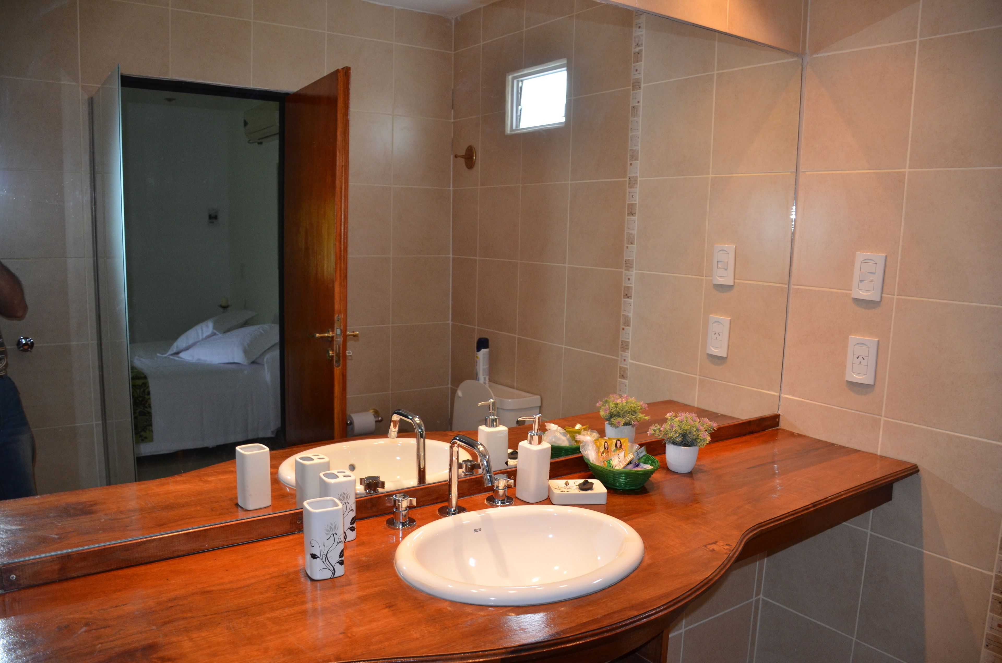 Une salle de bain avec un grand miroir, un lavabo et une douche.