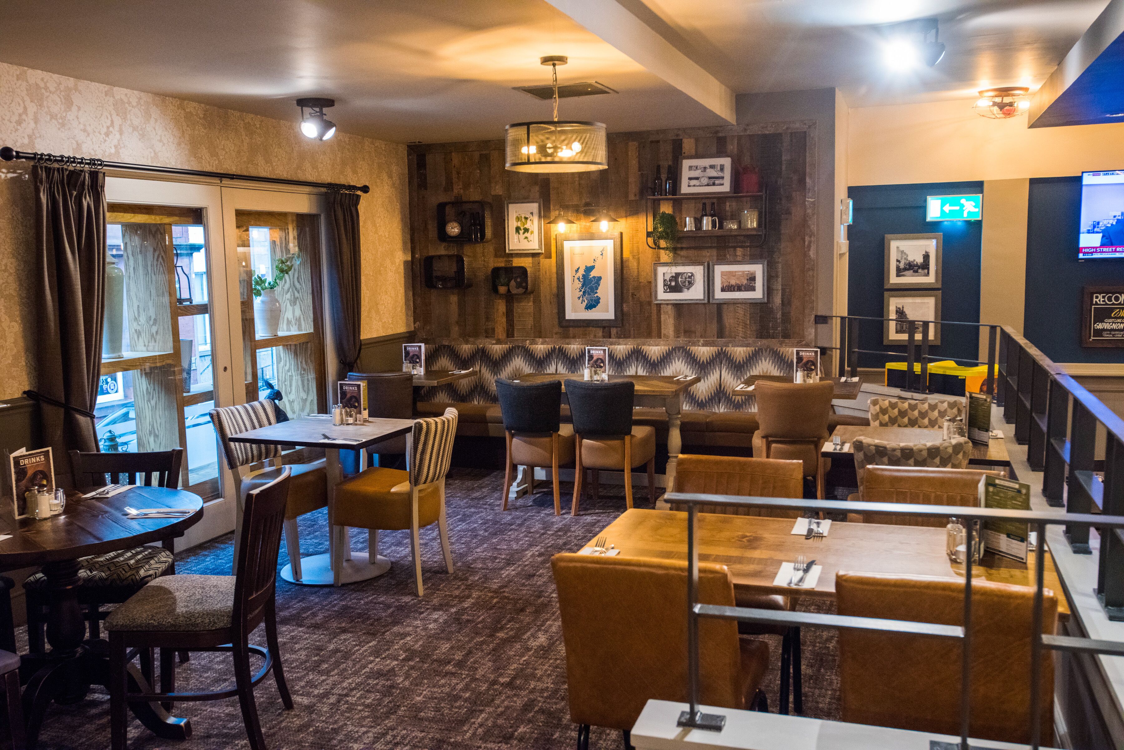 A restaurant with wooden walls, a bar area, and various seating options including tables and chairs.