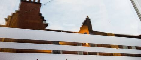 A sign for 'The Caledonian Bar' with a view of a building in the background.