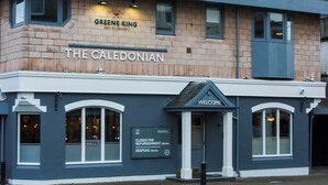 Un hotel llamado "The Caledonian" con un letrero que indica que está cerrado por remodelación hasta el 28 de octubre y reabrirá el 13 de noviembre.