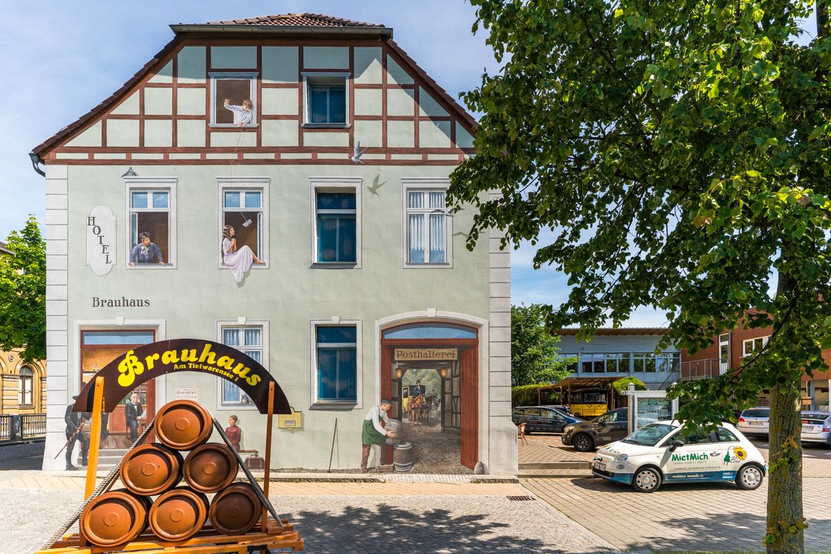 A traditional building with a sign reading "Hotel Brauhaus" and a beer barrel display outside.