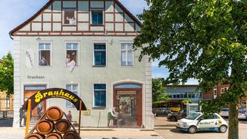 A traditional building with a sign reading "Hotel Brauhaus" and a beer barrel display outside.