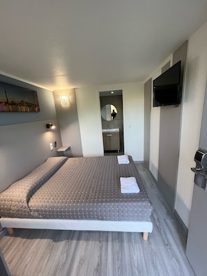 Relax in a spacious room with a large bed, flat-screen TV, and cozy seating area.