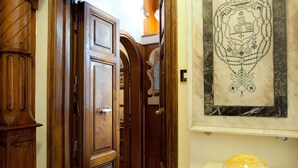 A hallway with wooden doors and a framed coat of arms on the wall. - Guesthouse Borromeo Roma (Rome)