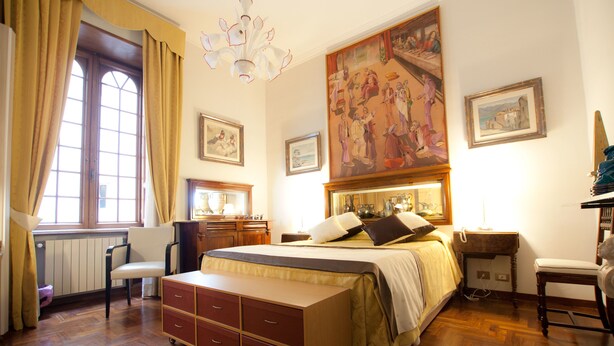 A bedroom with a large bed, a dresser, a chair, a desk, and a window with curtains. - Guesthouse Borromeo Roma (Rome)