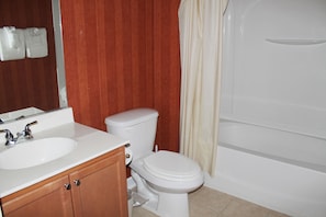 A bathroom with a white sink, toilet, and bathtub. - 1111 Willow Bend (North Myrtle Beach)