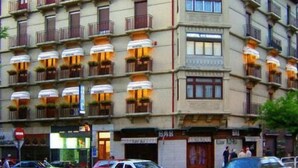 Et hotel med flere etager, balkoner, en bar og diverse butikker i stueetagen.