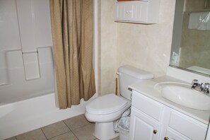 A bathroom with a toilet, sink, and bathtub. - 1815 Ironwood (North Myrtle Beach)