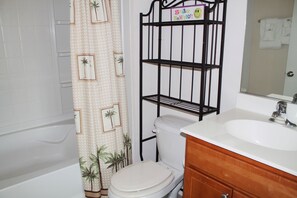 A bathroom with a bathtub, toilet, and a vanity with a sink. - 1534 Willow Bend (North Myrtle Beach)