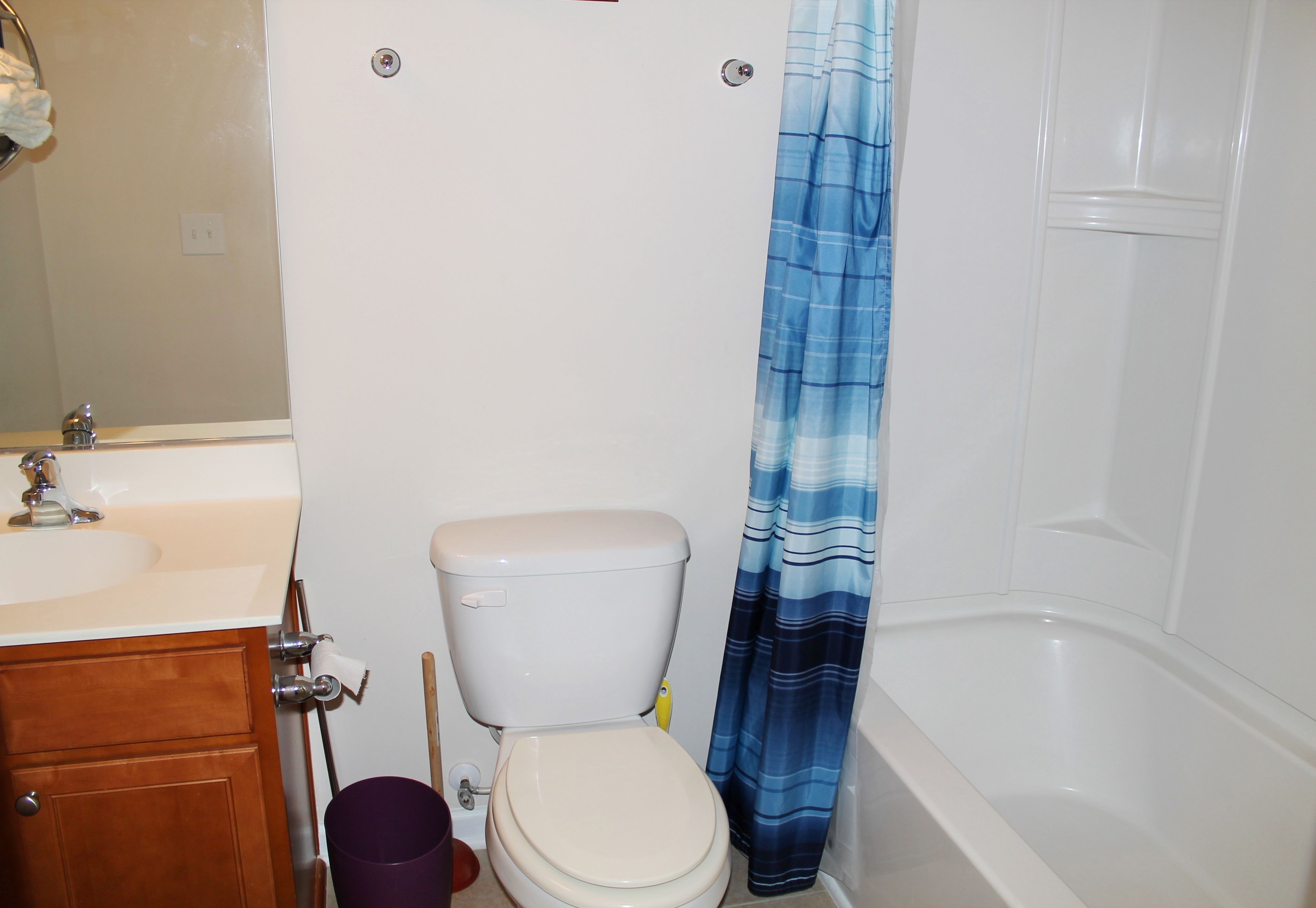 A bathroom with a toilet, sink, and bathtub.