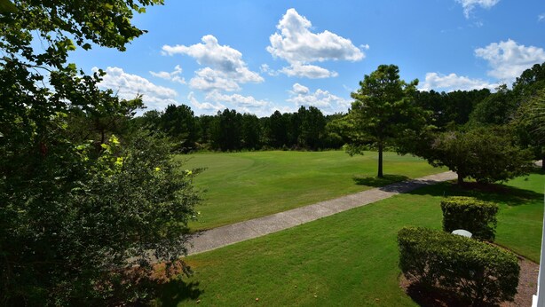 Un parcours de golf avec des allées bien définies, une pelouse verdoyante et luxuriante, et des arbres.