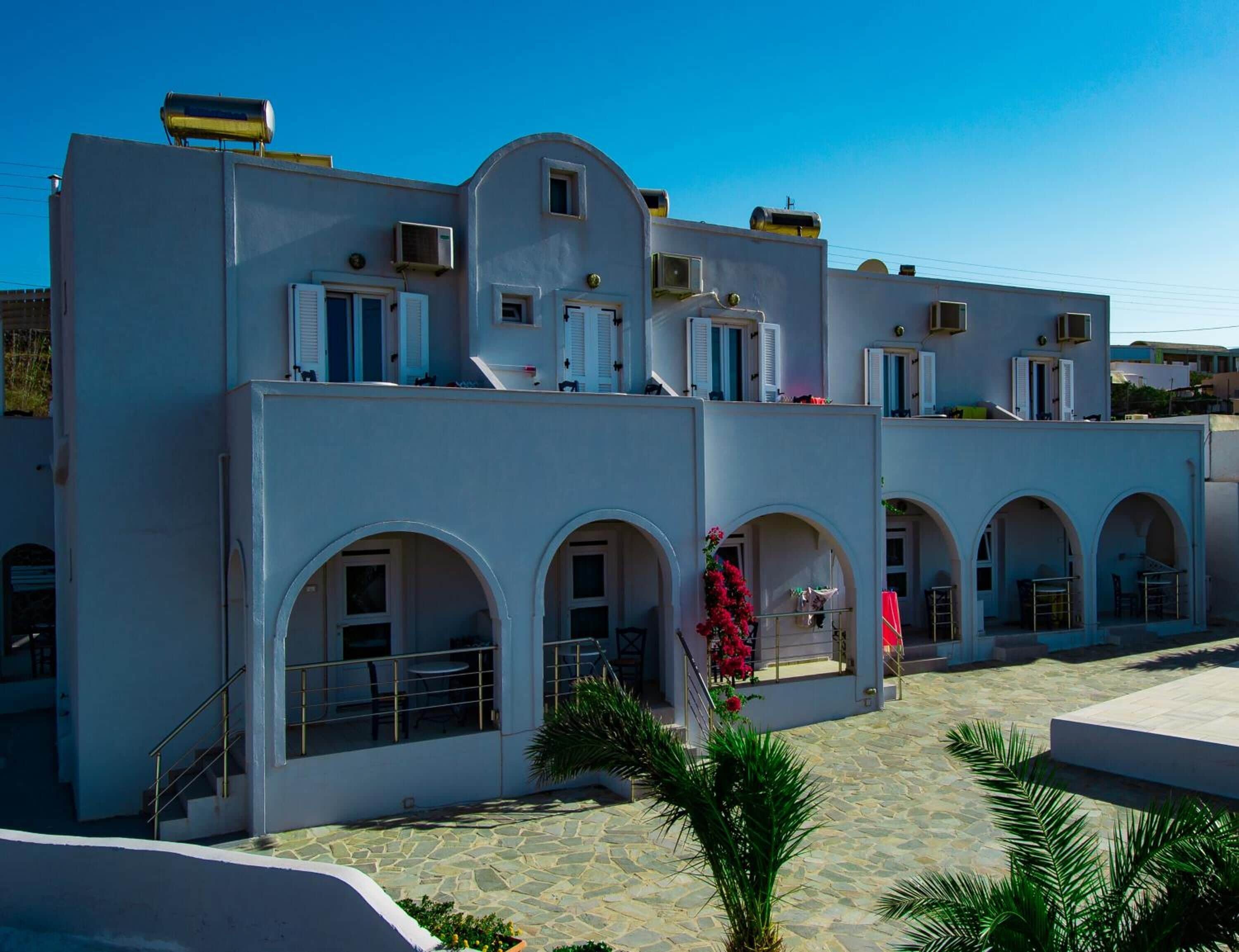 Un edificio de varios pisos con un patio central, que presenta arcos y una escalera que conduce a los pisos superiores.