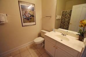 Un baño con inodoro, lavabo y un cuadro en la pared.