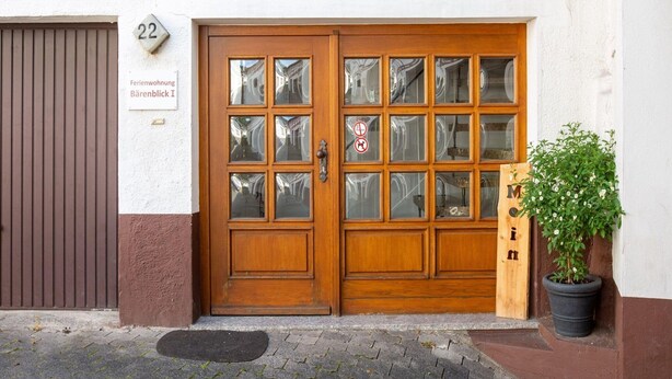 A wooden double door with glass panels, a sign with the number 22, and a potted plant on the right. - Wohnung in Battenberg nahe Winterberg Skigebiet (Battenberg)