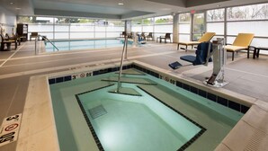 A swimming pool with a 3-foot depth marker, lounge chairs, and a sunbed. - Hampton Inn & Suites Seattle/Redmond (Redmond)