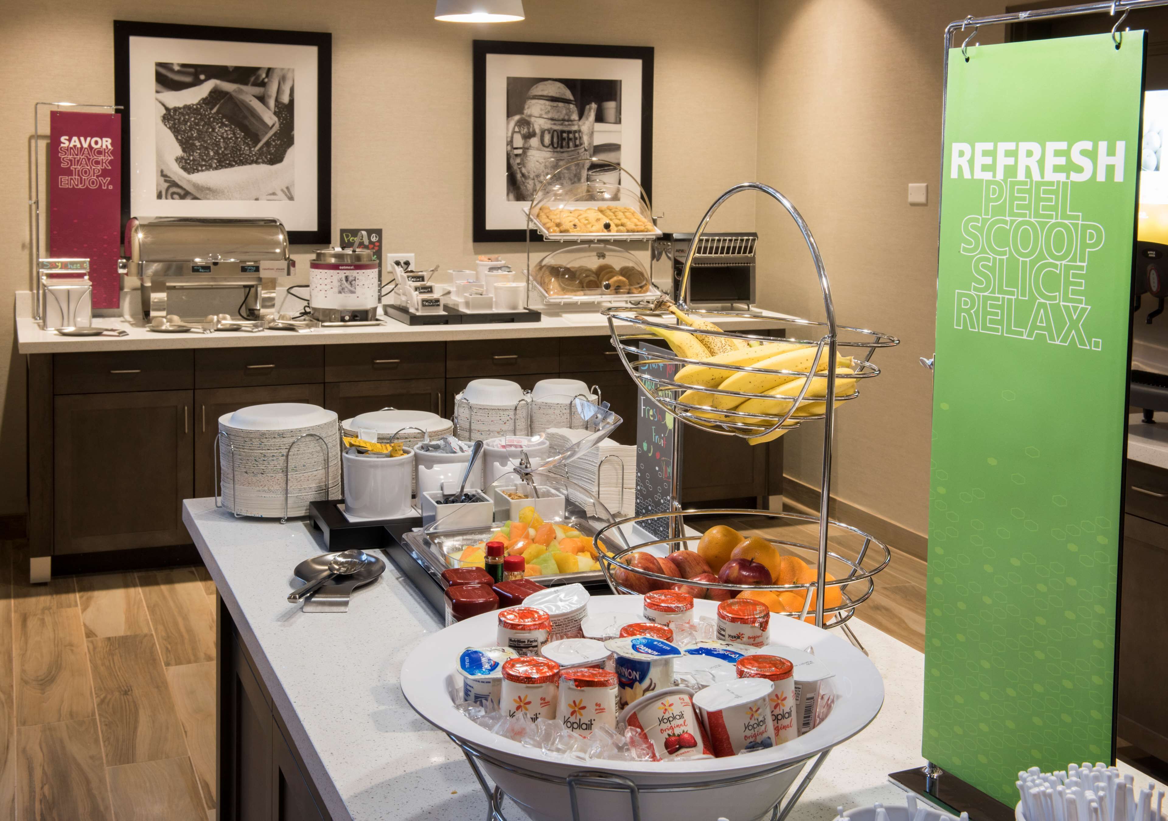 Un'area buffet con diversi cibi, tra cui frutta, dolci e bevande.