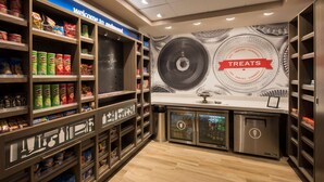 A snack store with shelves stocked with various snacks and a wall mural advertising treats. - Hampton Inn & Suites Seattle/Redmond (Redmond)