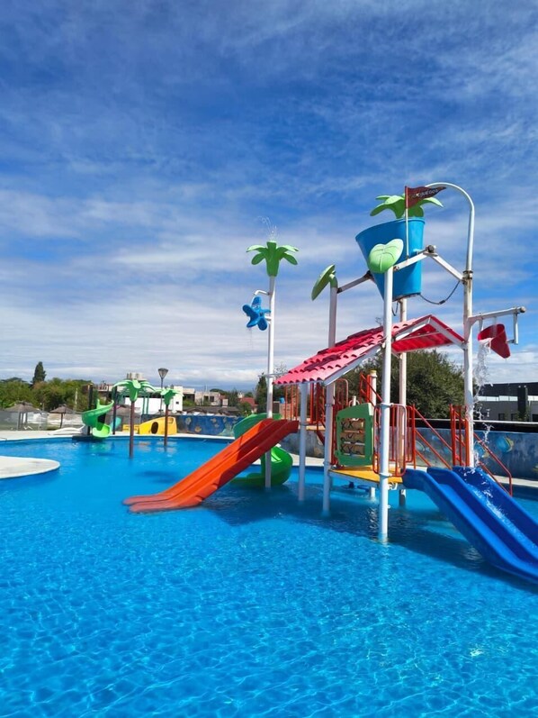 A swimming pool with multiple slides and water features.