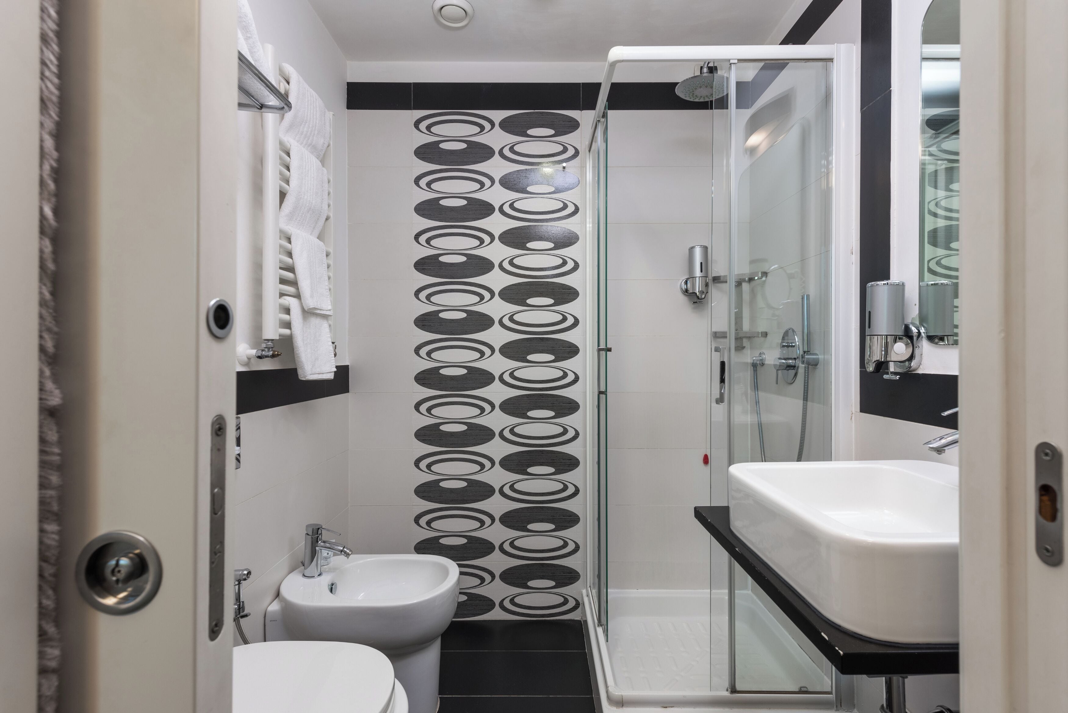 A compact bathroom with a glass shower enclosure, a white sink, and a toilet.