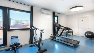 A gym with a treadmill, stationary bike, and elliptical machine.