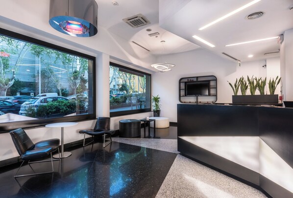 A modern reception area with a large window, seating, and a reception desk.