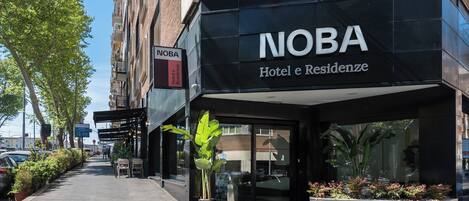 A hotel entrance with a sign reading "NOBA Hotel e Residenze".