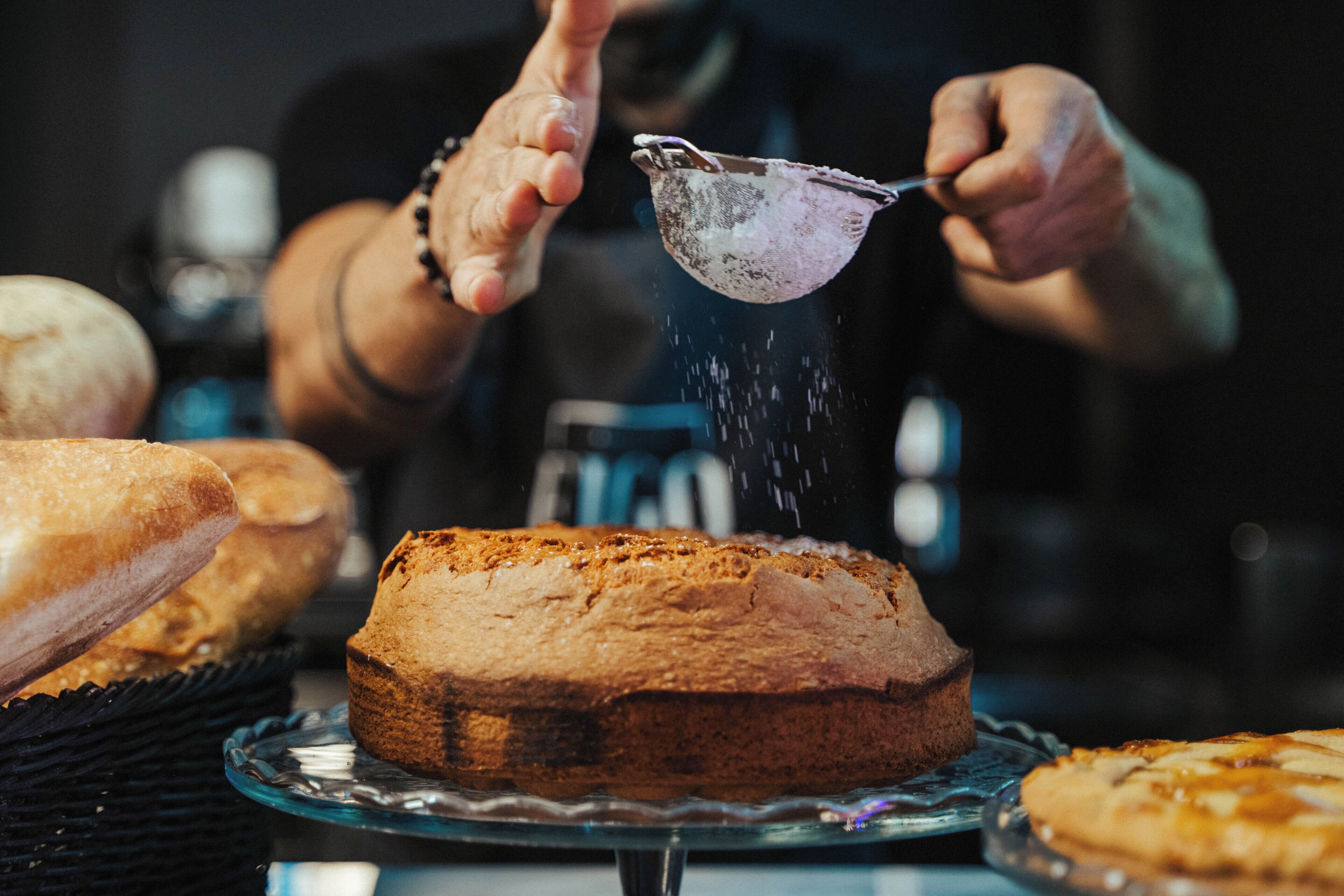 A loaf of bread on a glass plate with a dusting of flour.