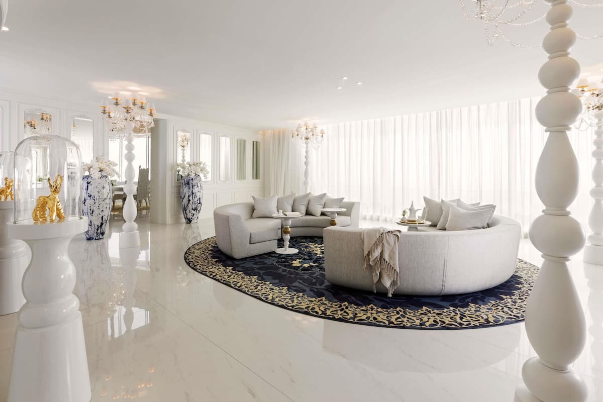 A spacious living room with a round coffee table, two sofas, and a chandelier.