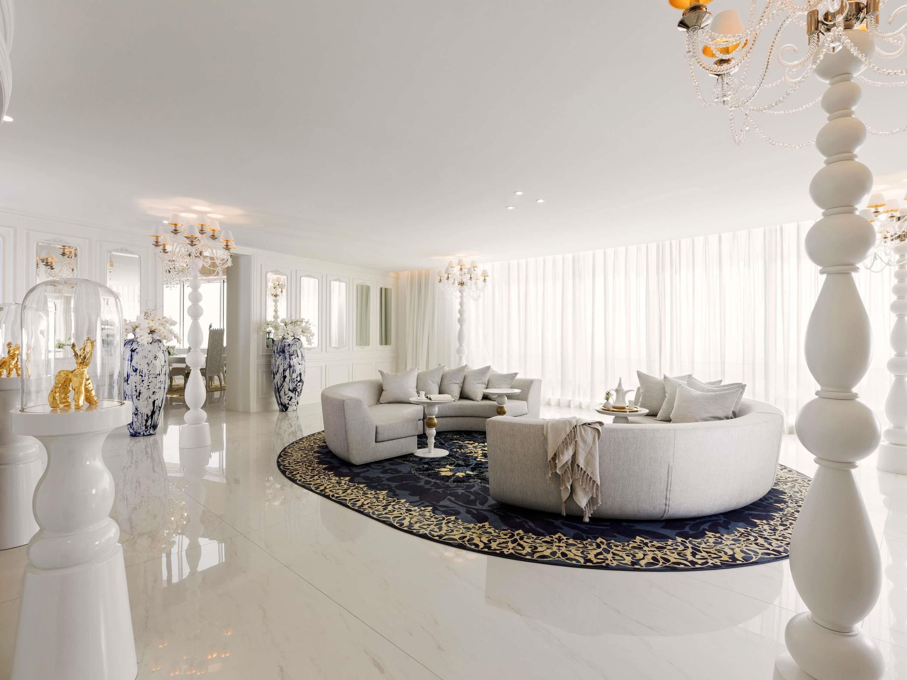 A spacious living room with a round coffee table, two sofas, and a chandelier.