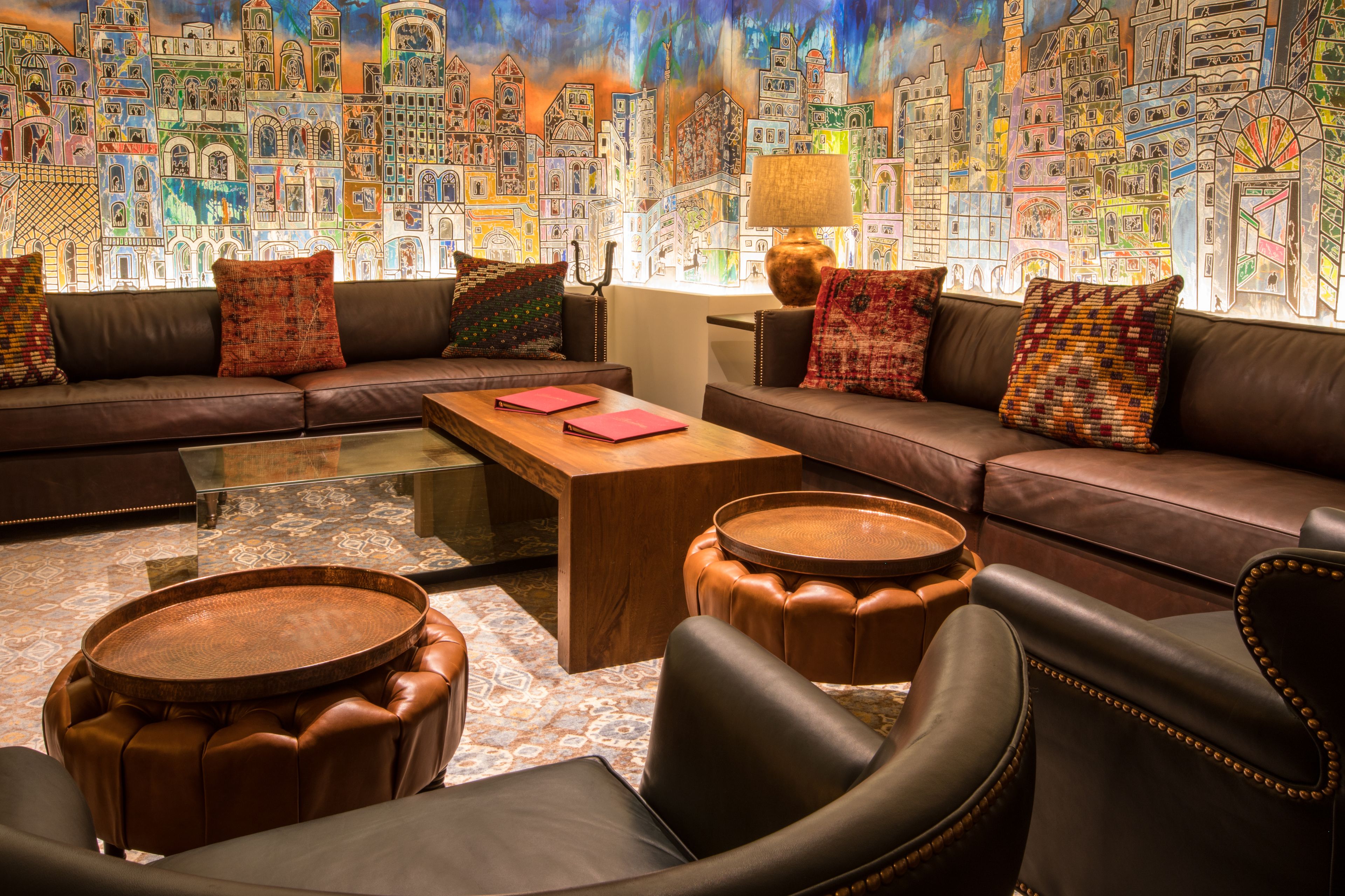 A modern lounge area with a sofa set, a coffee table, and two round wooden side tables.