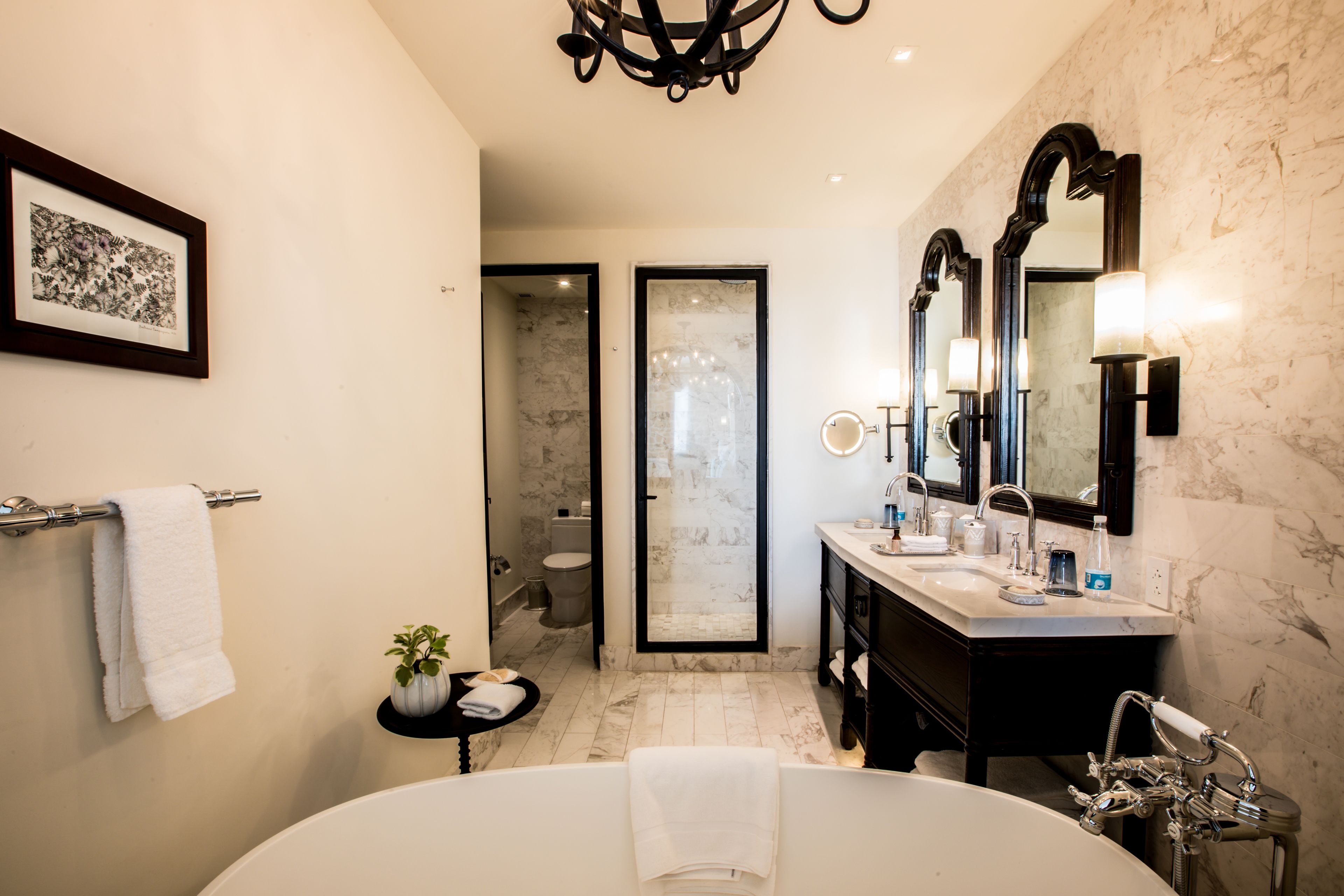 A modern bathroom with a large bathtub, a separate shower area, and a vanity with a mirror.