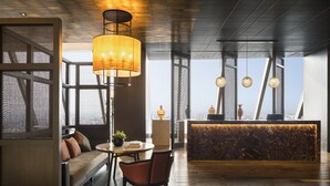 Un interior moderno con techo de madera, un sofá, una mesa redonda y una recepción con vistas.