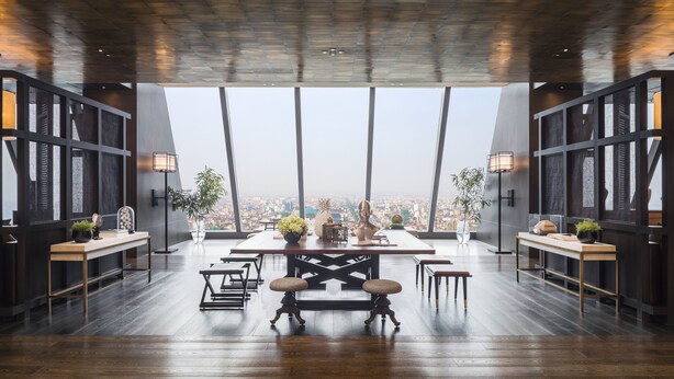 Un comedor moderno con techo alto, ventanas amplias y vistas a la ciudad.